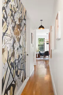 a view of a livingroom with wooden floor and furniture