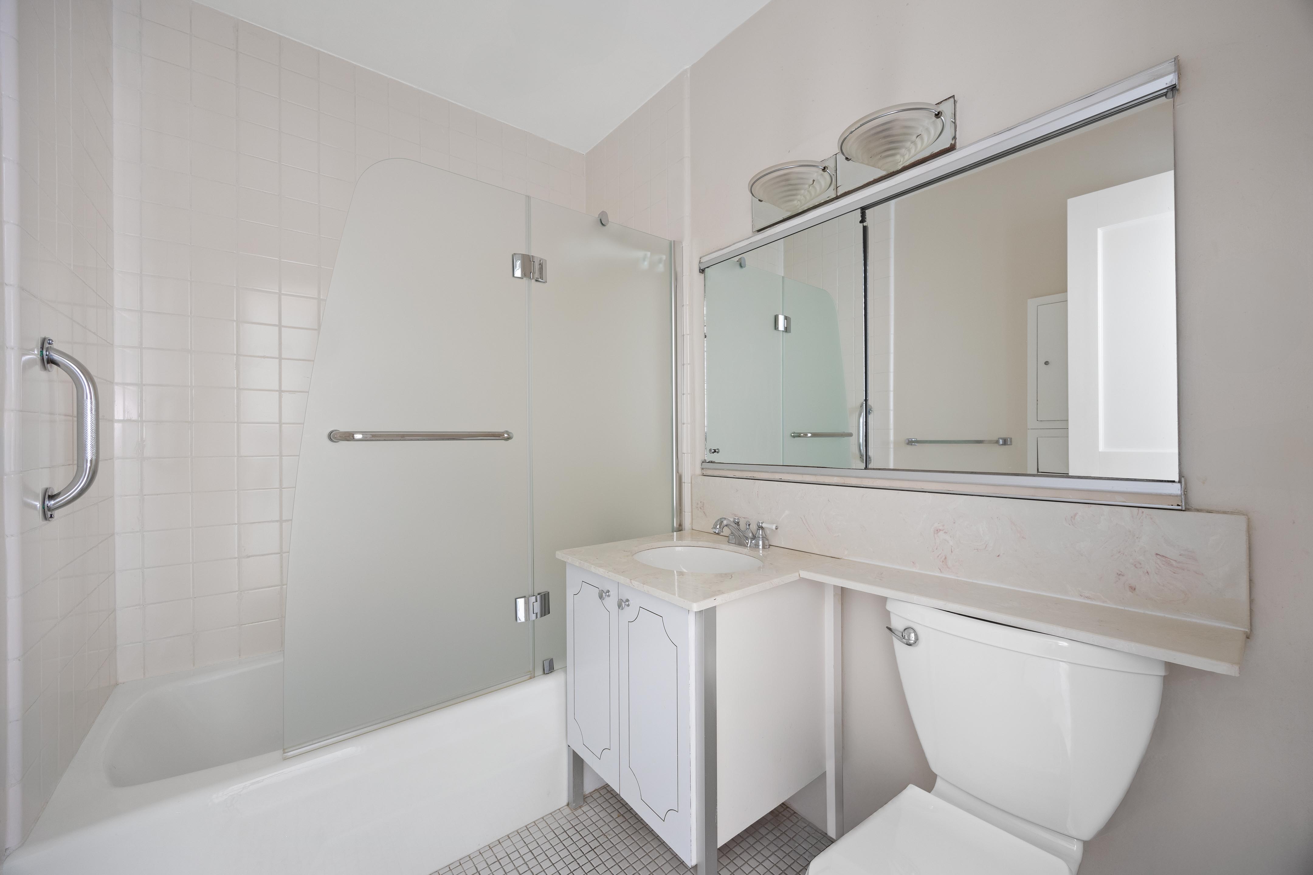 159 West 53rd Street, Unit 16E Manhattan, NY 10019 - Photo 9 of 10 a bathroom with a sink a toilet and shower