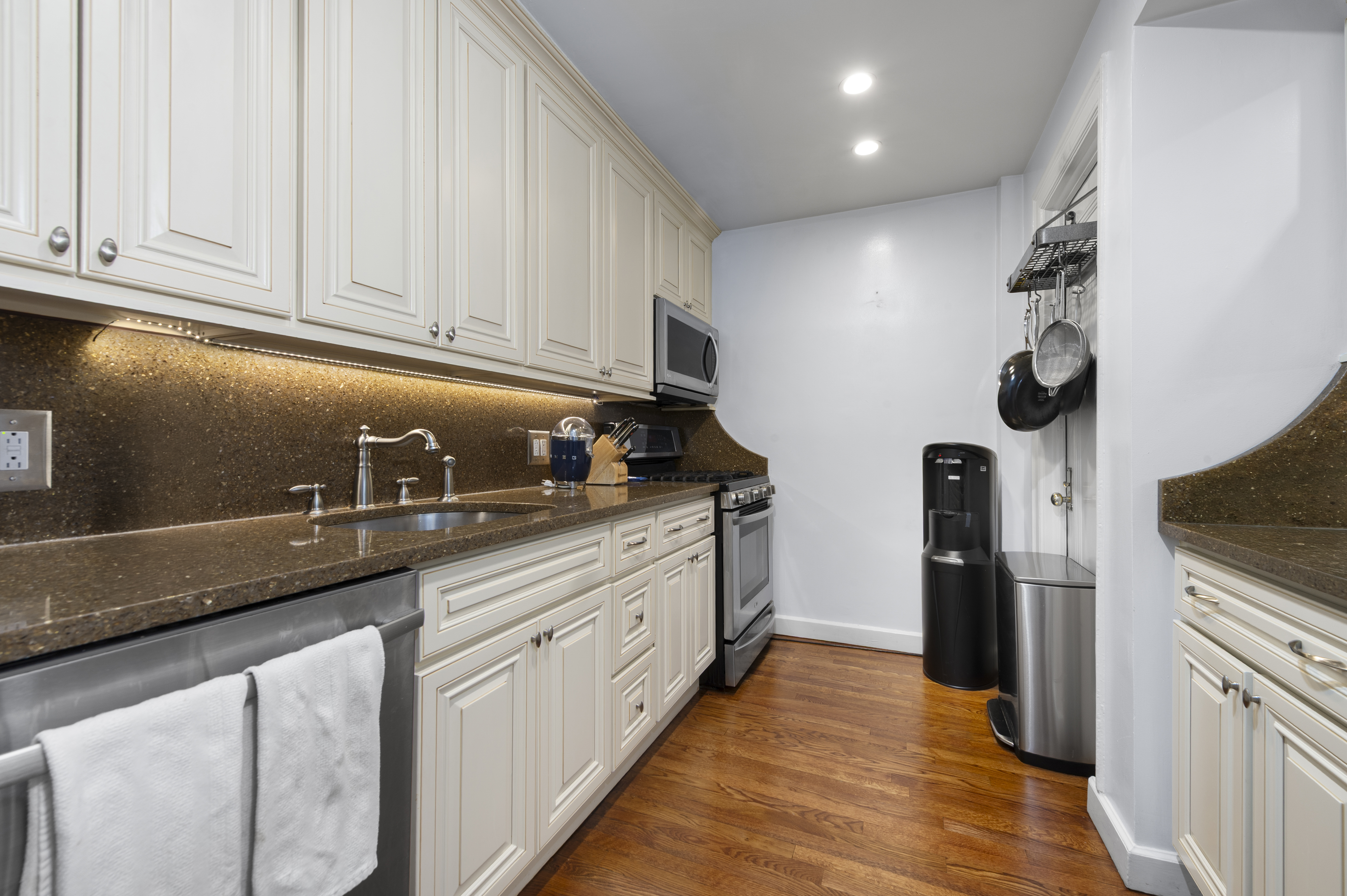 1 West 67th Street, Unit 2M Manhattan, NY 10023 - Photo 5 of 15 a kitchen with granite countertop a sink and stainless steel appliances