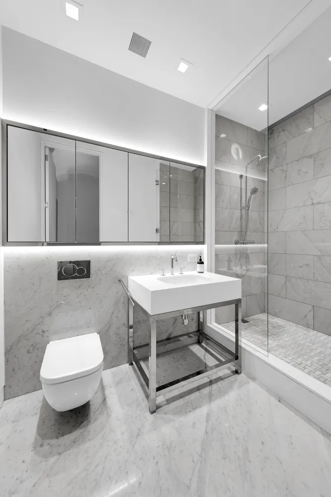 a bathroom with a sink a toilet a mirror and bathtub