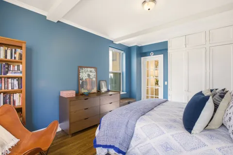 a bedroom with a bed and a book shelf