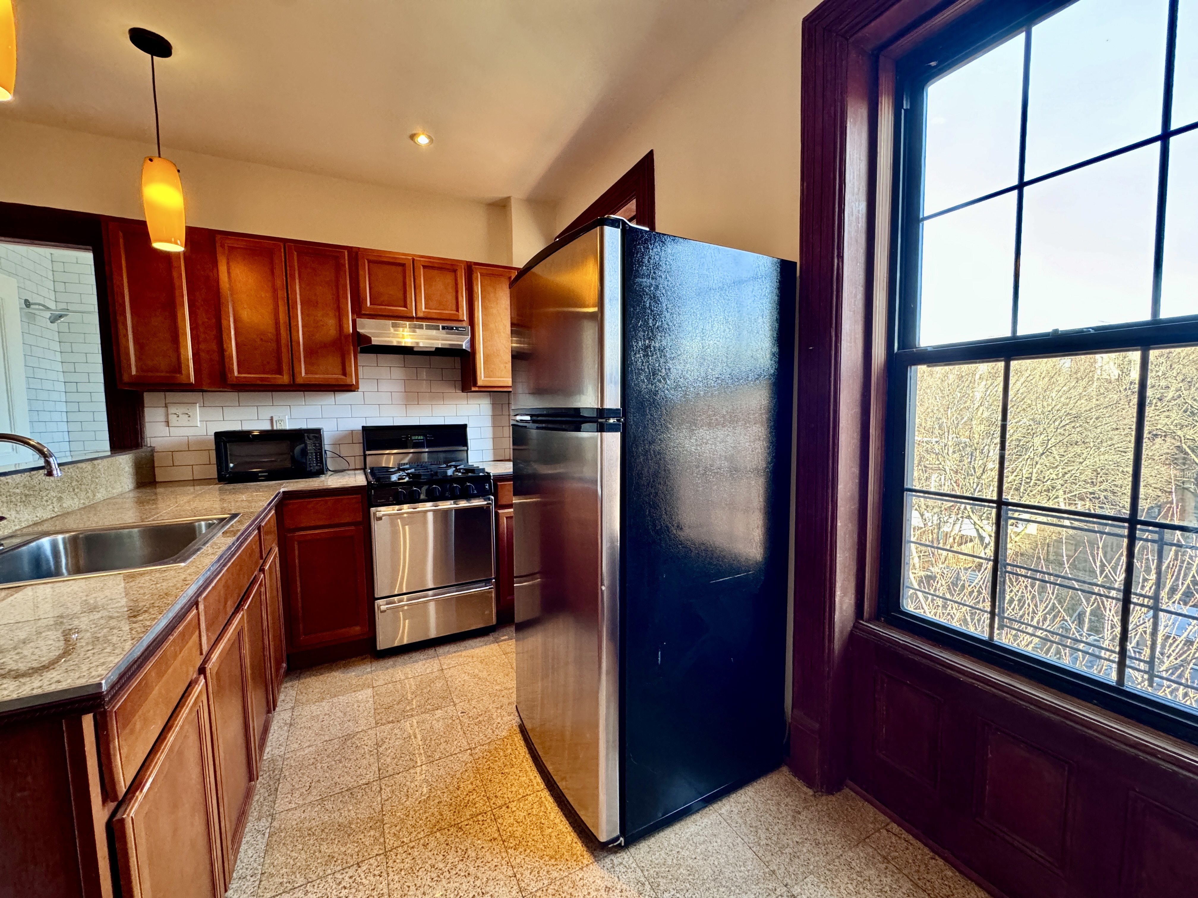 15 Arlington Place, Unit 3 Brooklyn, NY 11216 - Photo 4 of 14 a kitchen with stainless steel appliances granite countertop a refrigerator a sink dishwasher a stove with wooden cabinets