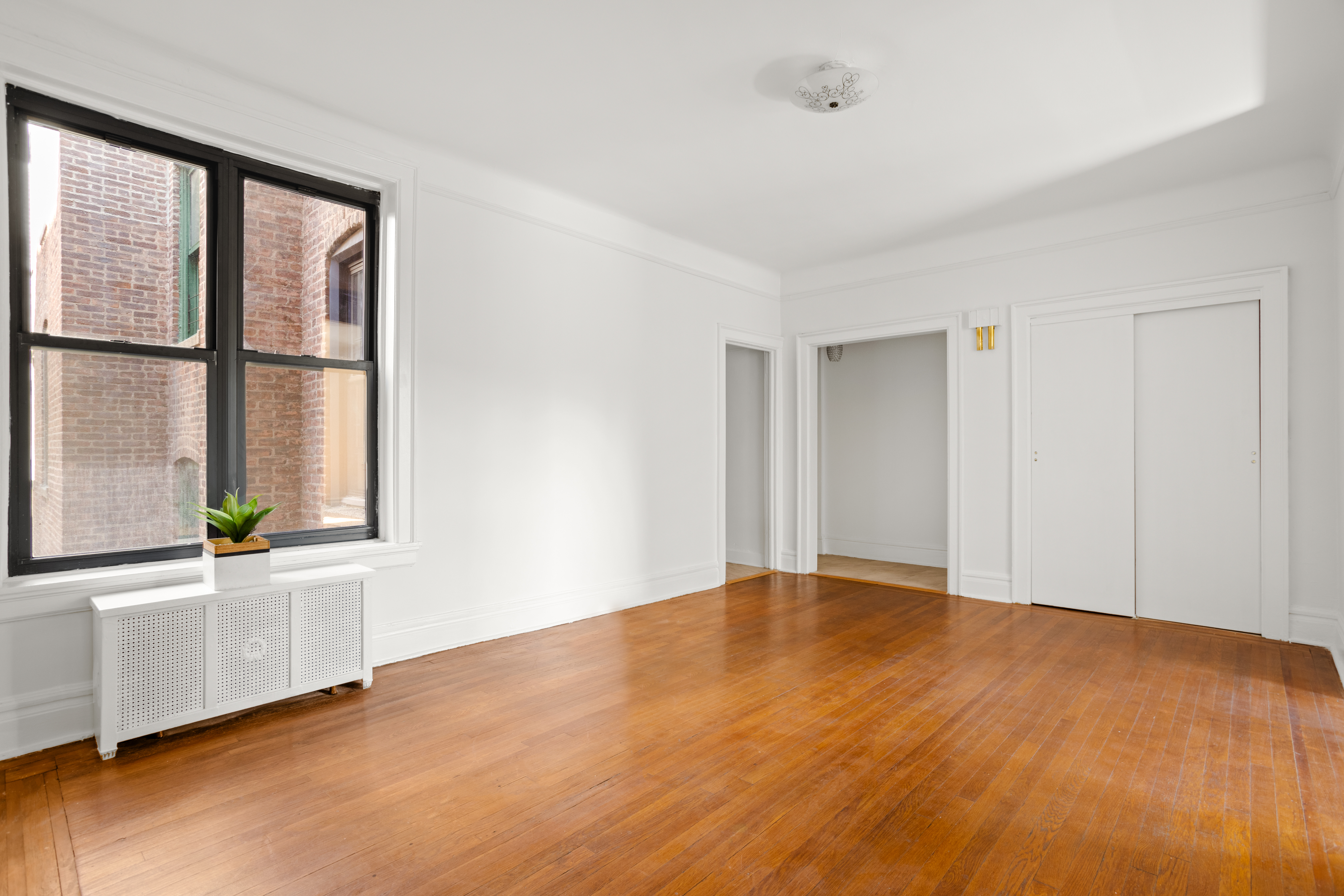 35-30 82nd Street, Unit 32 Queens, NY 11372 - Photo 2 of 11 a view of an empty room with a window and wooden floor