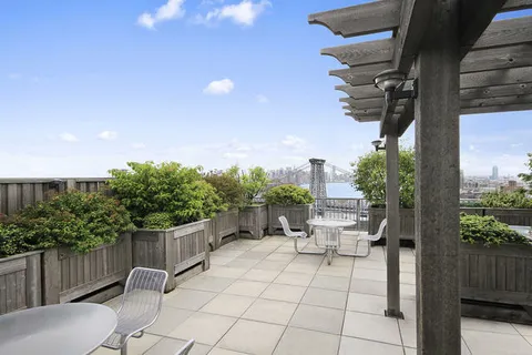 a view of a patio with table and chairs with wooden fence