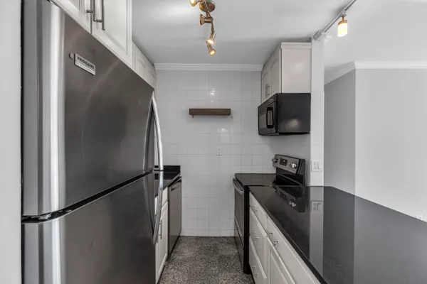 a kitchen with stainless steel appliances a refrigerator a stove a microwave and cabinets