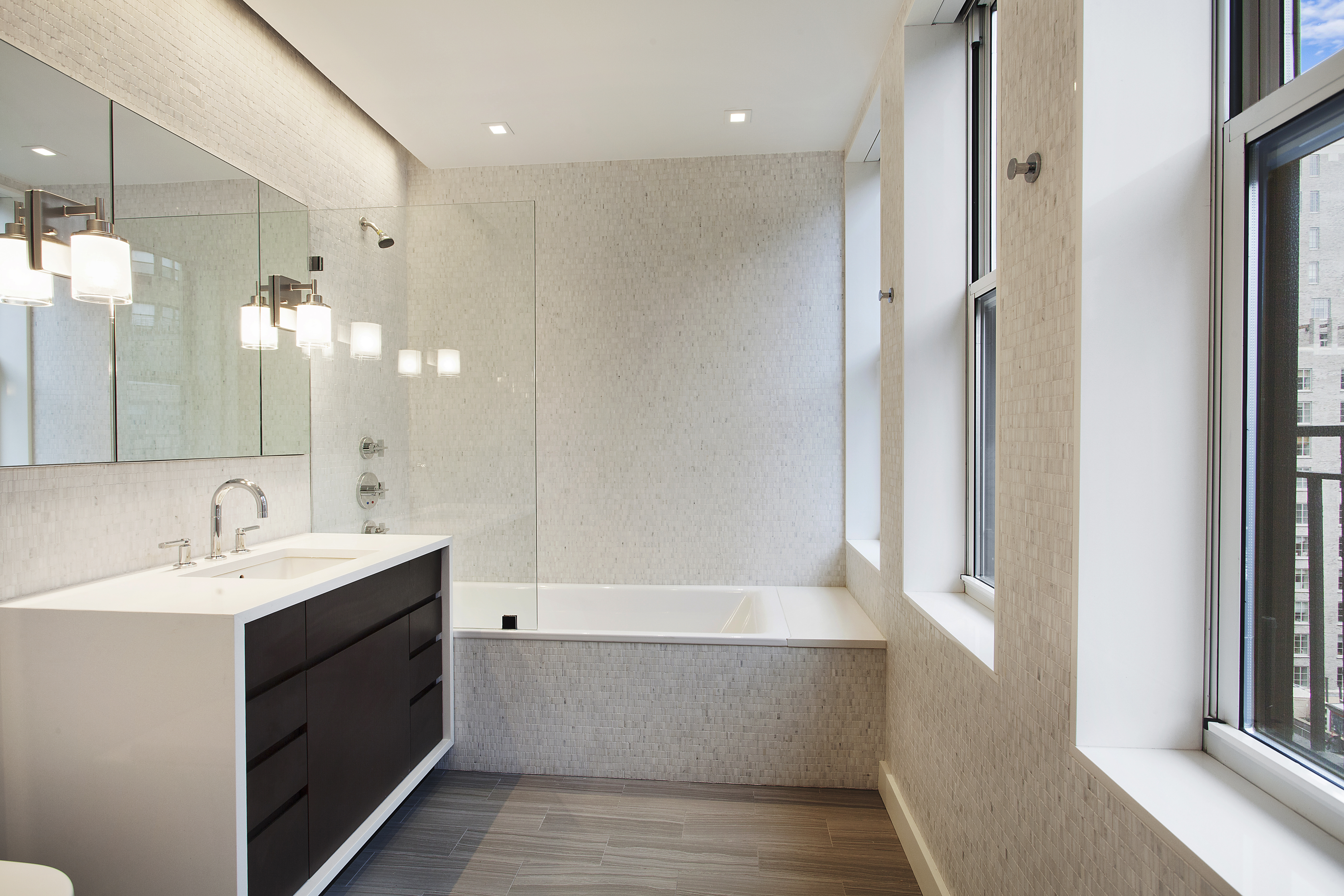 East 80th Street Manhattan, NY 10075 - Photo 10 of 13 a bathroom with a double vanity sink a mirror and a bathtub