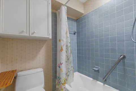 a bathroom with a granite countertop toilet sink and mirror