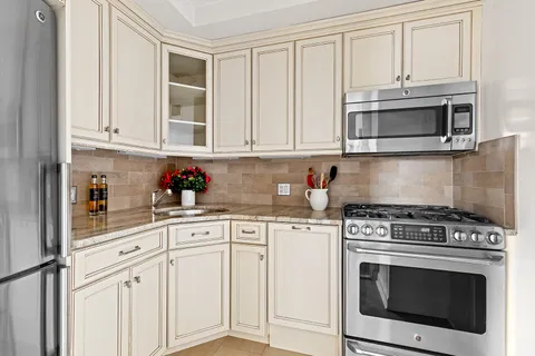 a kitchen with granite countertop white cabinets and stainless steel appliances