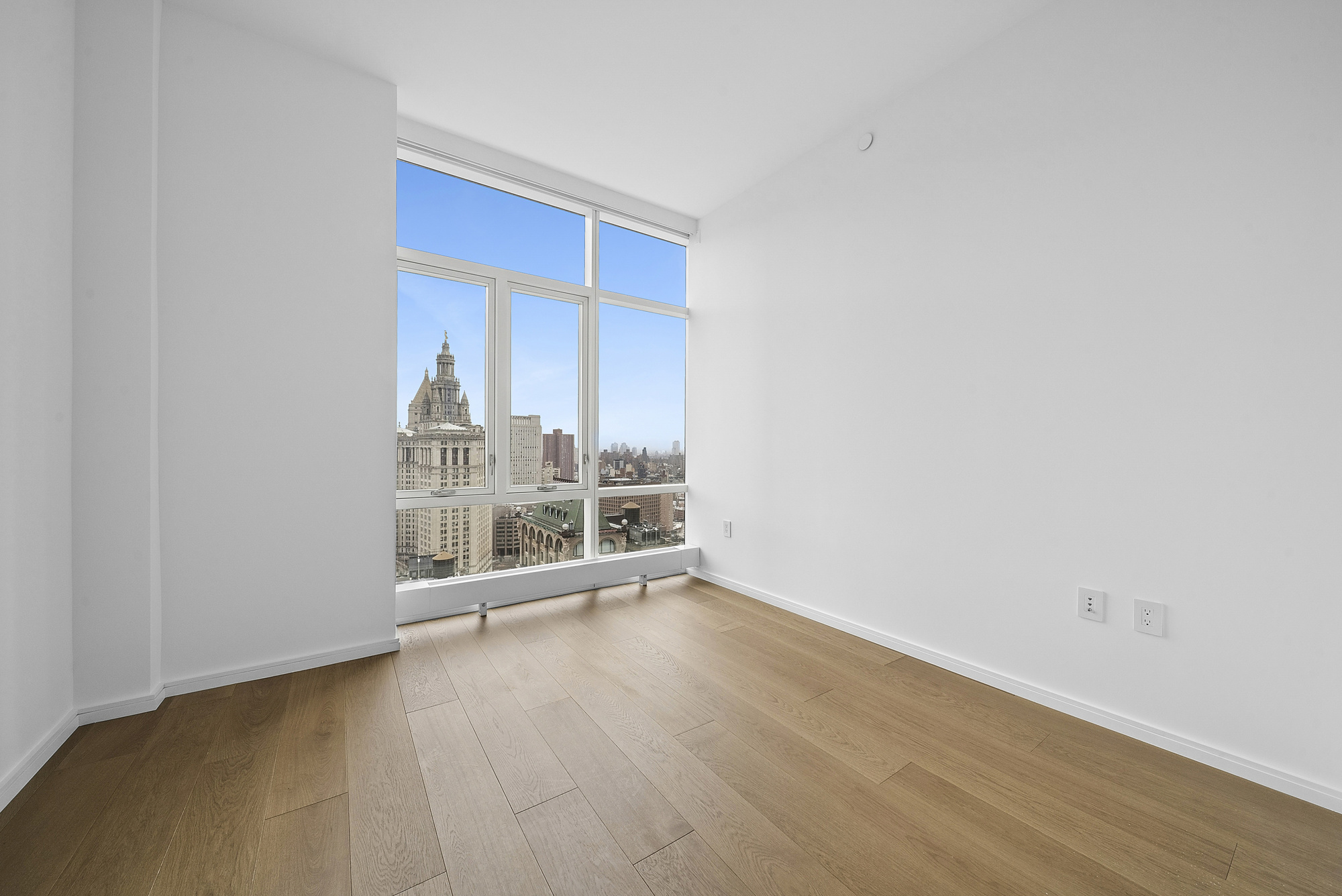 5 Beekman Street, Unit 30A Manhattan, NY 10038 - Photo 7 of 15 an empty room with wooden floor and windows