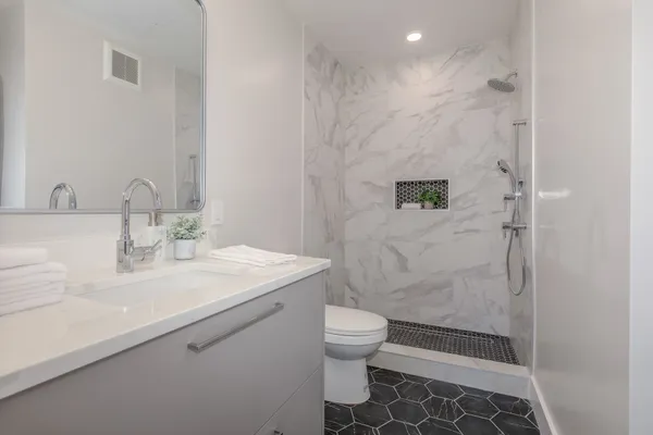 a bathroom with a sink a toilet and shower