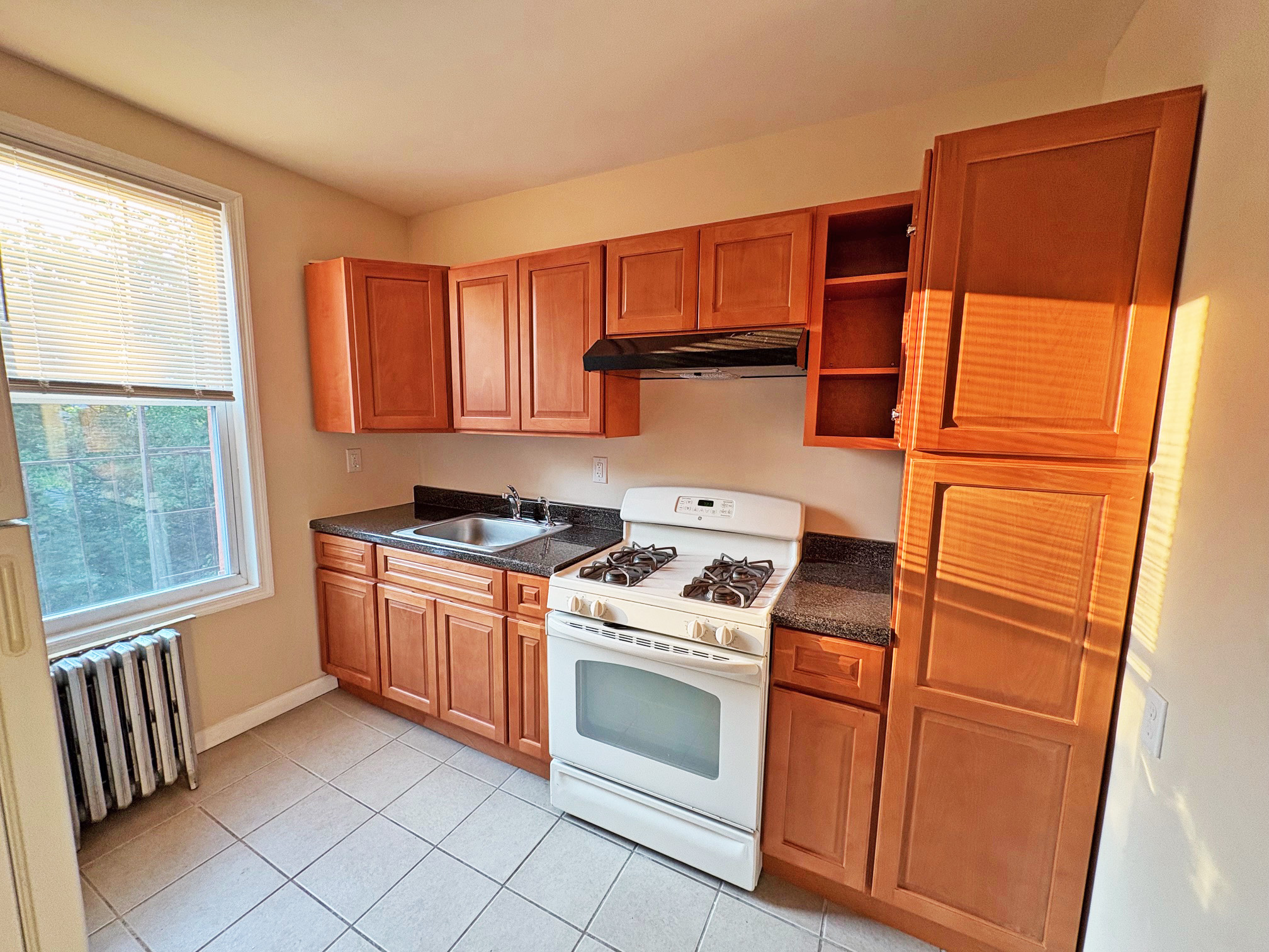 179 Covert Street, Unit 3 Brooklyn, NY 11207 - Photo 12 of 14 a kitchen with stainless steel appliances granite countertop a stove a sink and a refrigerator