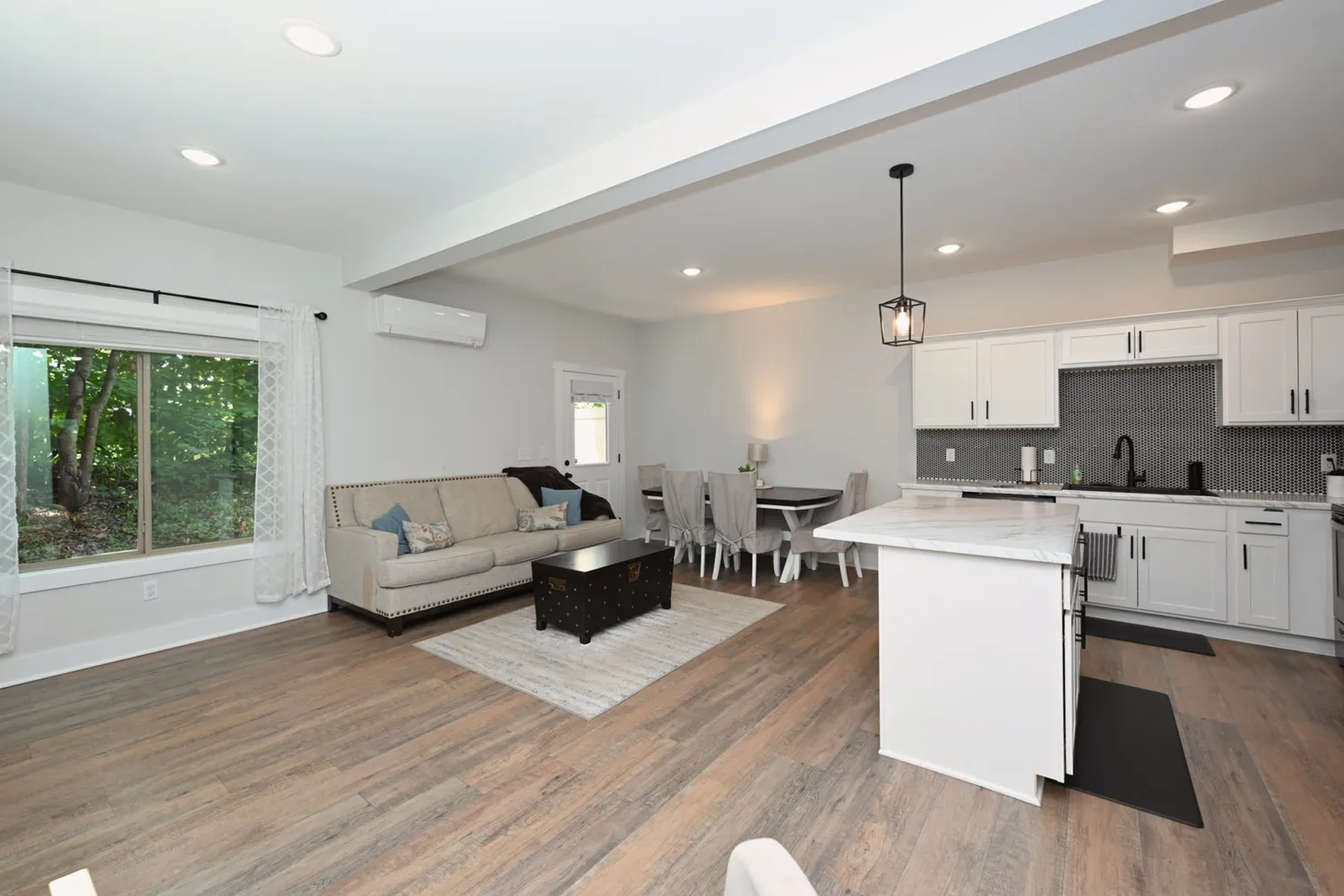 a living room with furniture and kitchen view