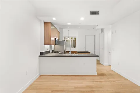 a large white kitchen with a sink and dishwasher