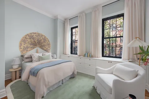 a bedroom with a bed and a large window
