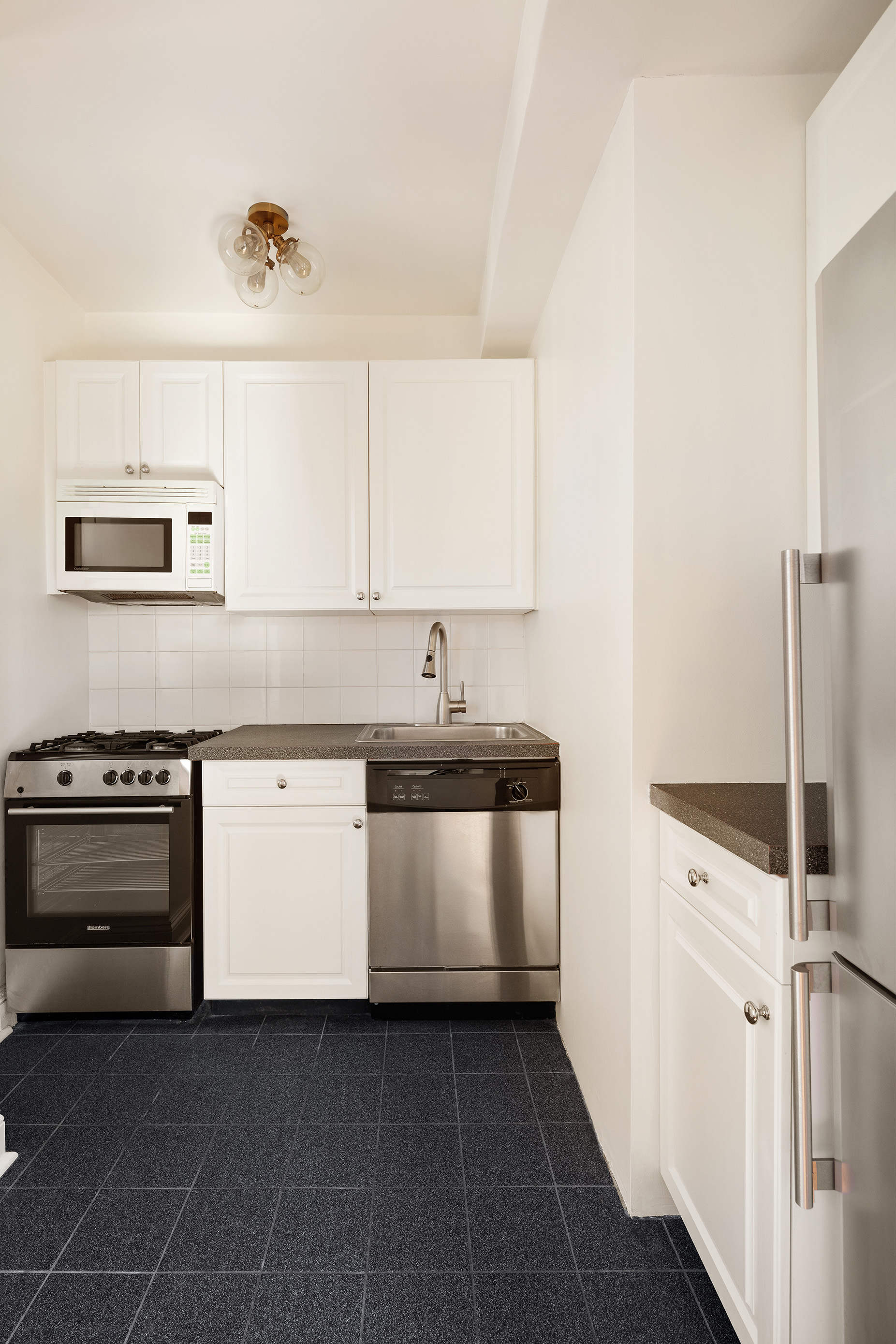 200 East 16th Street, Unit 16L Manhattan, NY 10003 - Photo 3 of 12 a kitchen with a stove and a sink