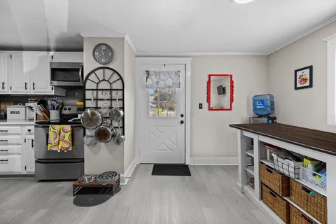 a view of kitchen with stainless steel appliances cabinets and a window