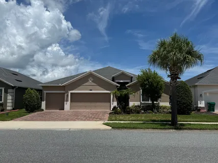 a front view of a house with a garden and trees