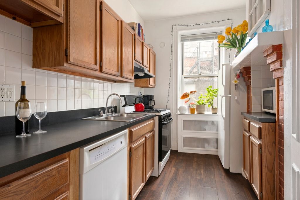 a kitchen with stainless steel appliances granite countertop a sink and a refrigerator