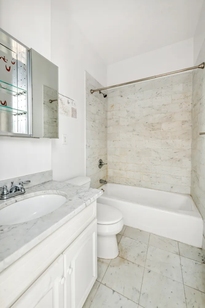 a bathroom with a granite countertop sink a toilet and bathtub
