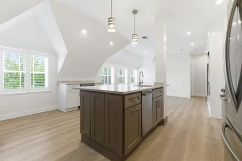 a kitchen with kitchen island granite countertop a sink counter top space and stainless steel appliances