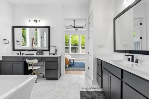 a bathroom with a sink vanity tub and a mirror