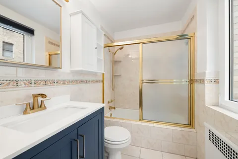 a bathroom with a granite countertop sink toilet and shower