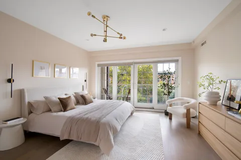 a bedroom with a large bed and windows