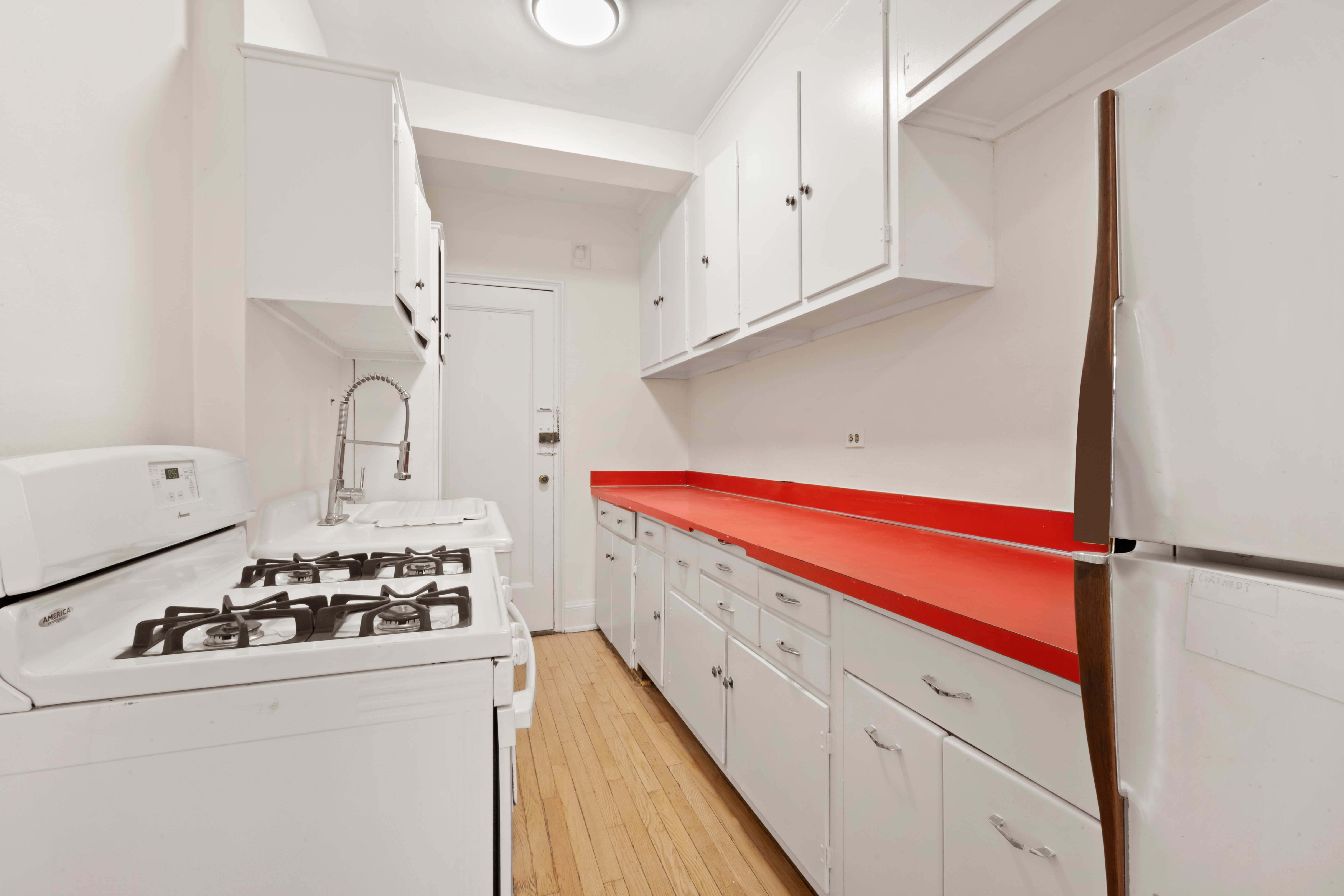 136 East 36th Street, Unit 3B Manhattan, NY 10016 - Photo 5 of 10 a kitchen with white cabinets and white appliances