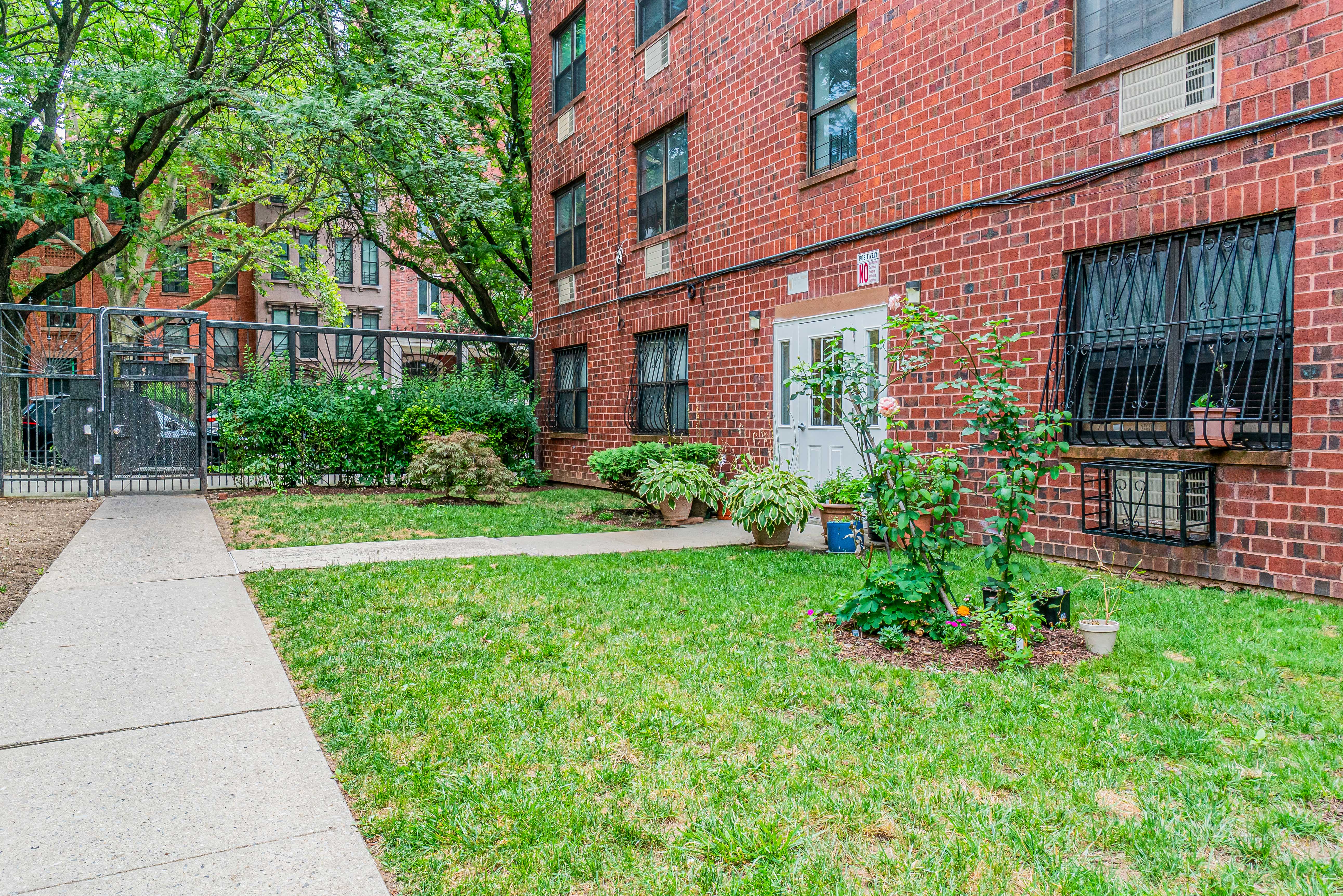 7 Gates Avenue, Unit H Brooklyn, NY 11238 - Photo 17 of 20 a view of a brick house with a yard and plants