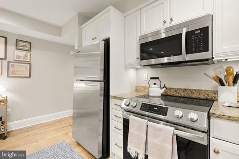 a kitchen with stainless steel appliances granite countertop a stove microwave and refrigerator