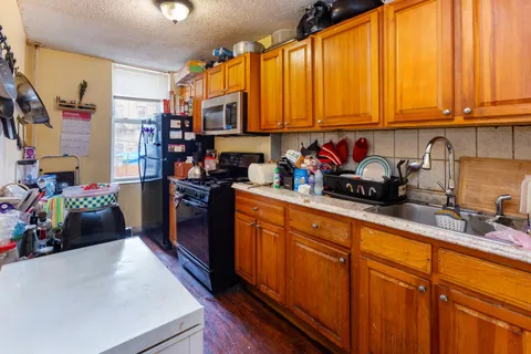 a kitchen with stainless steel appliances granite countertop a refrigerator and a stove top oven