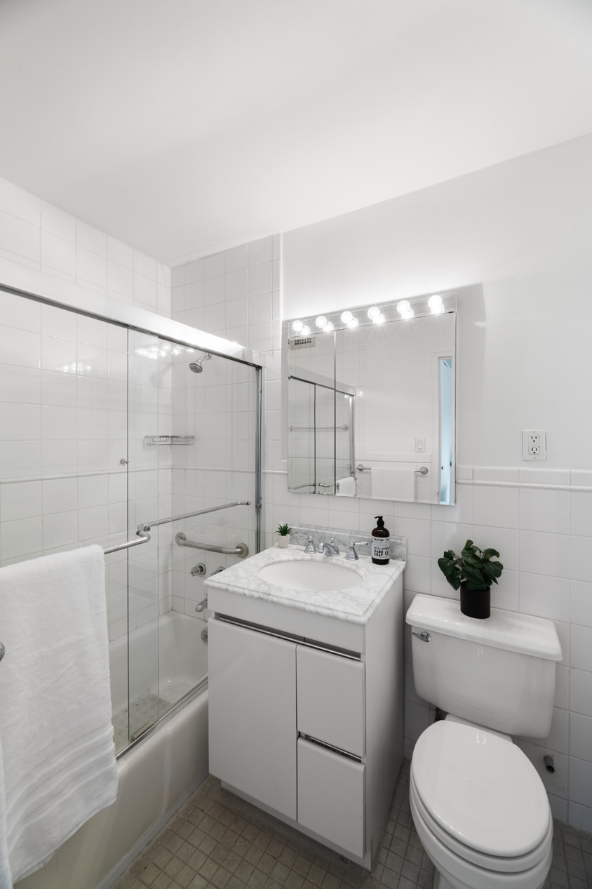 2500 Johnson Avenue, Unit 5E Bronx, NY 10463 - Photo 7 of 12 a bathroom with a sink toilet vanity and shower