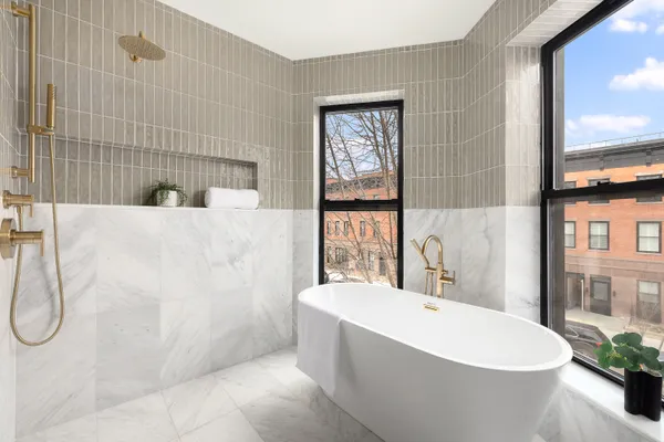 a white bath tub sitting in a bathroom next to a window