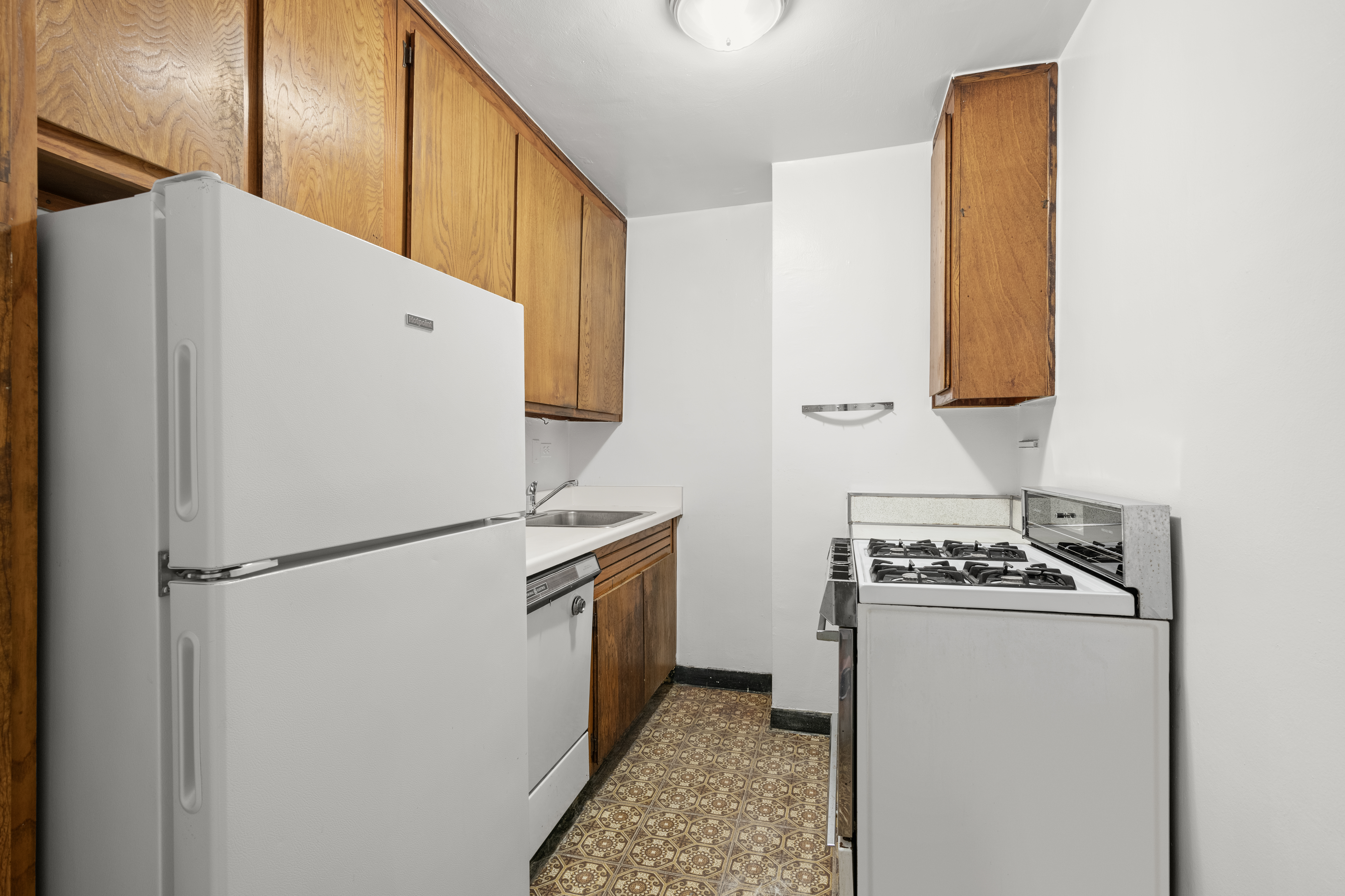 245 East 25th Street, Unit 8K Manhattan, NY 10010 - Photo 5 of 7 a white refrigerator freezer and a stove sitting inside of a kitchen