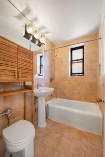 a bathroom with a sink a toilet a mirror and bathtub