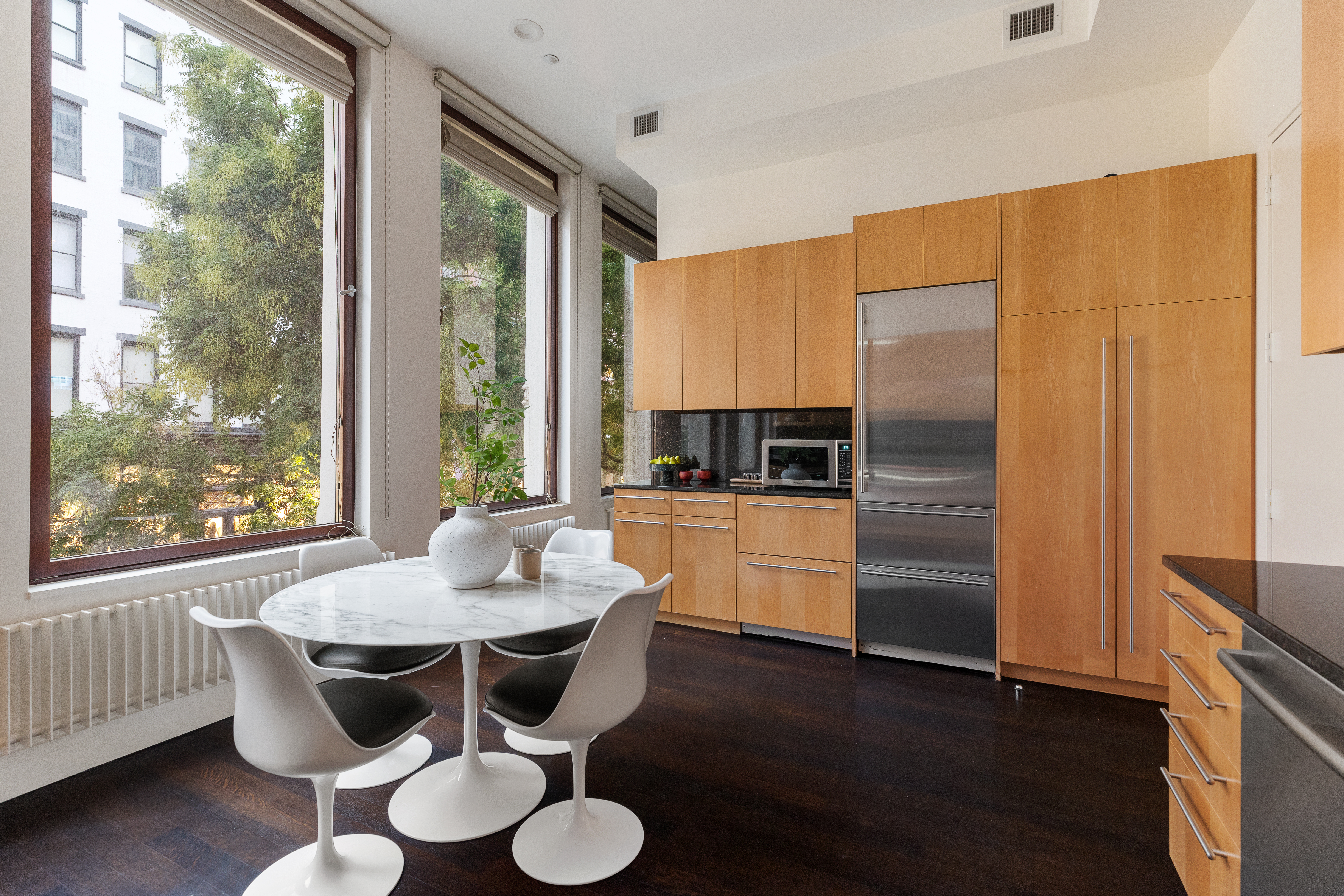 388 West Broadway, Unit 2 Manhattan, NY 10012 - Photo 8 of 27 a kitchen with stainless steel appliances granite countertop a kitchen island hardwood floor a sink and a window