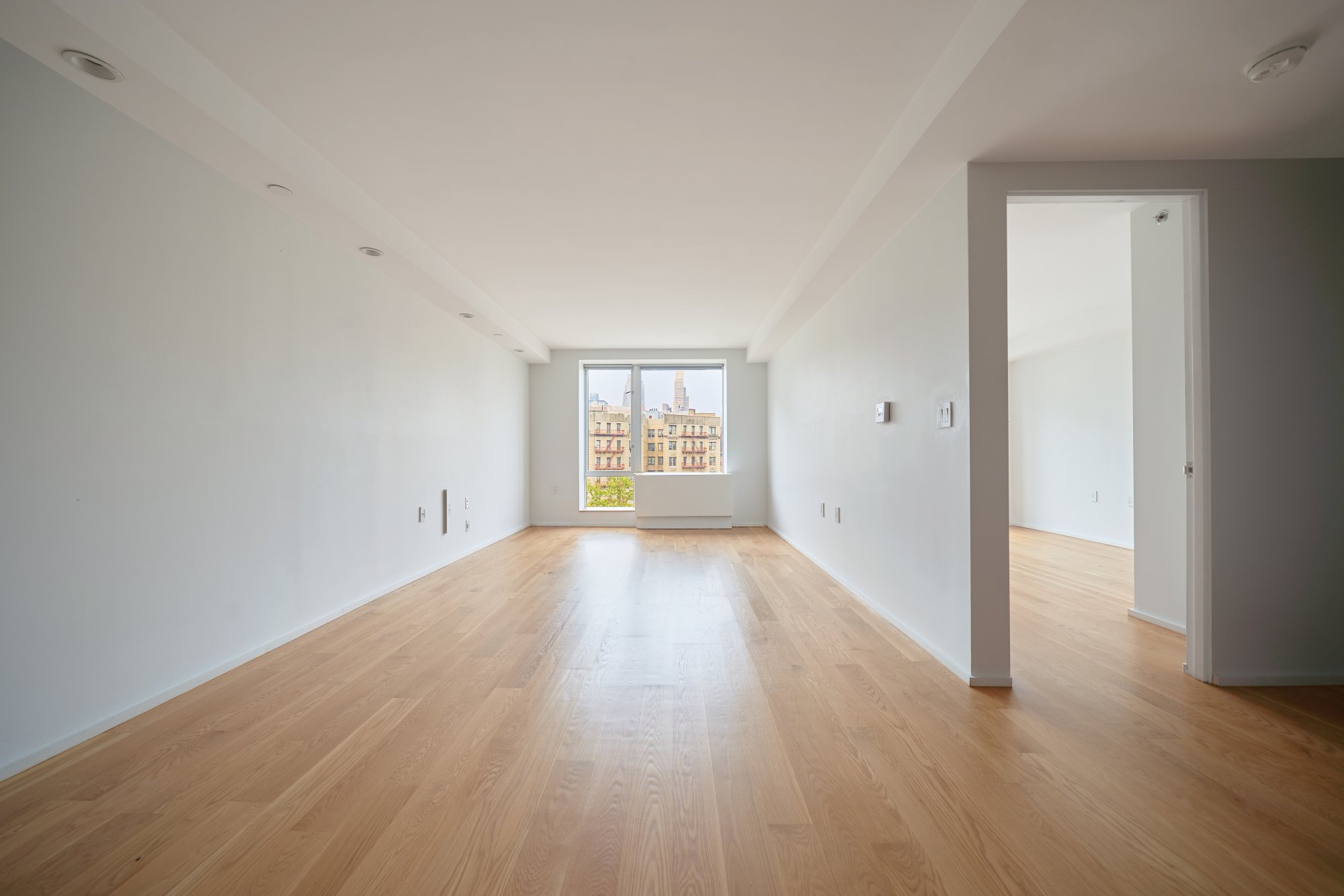 2280 Frederick Douglass Boulevard, Unit 5D Manhattan, NY 10027 - Photo 6 of 22 wooden floor in an empty room with a window
