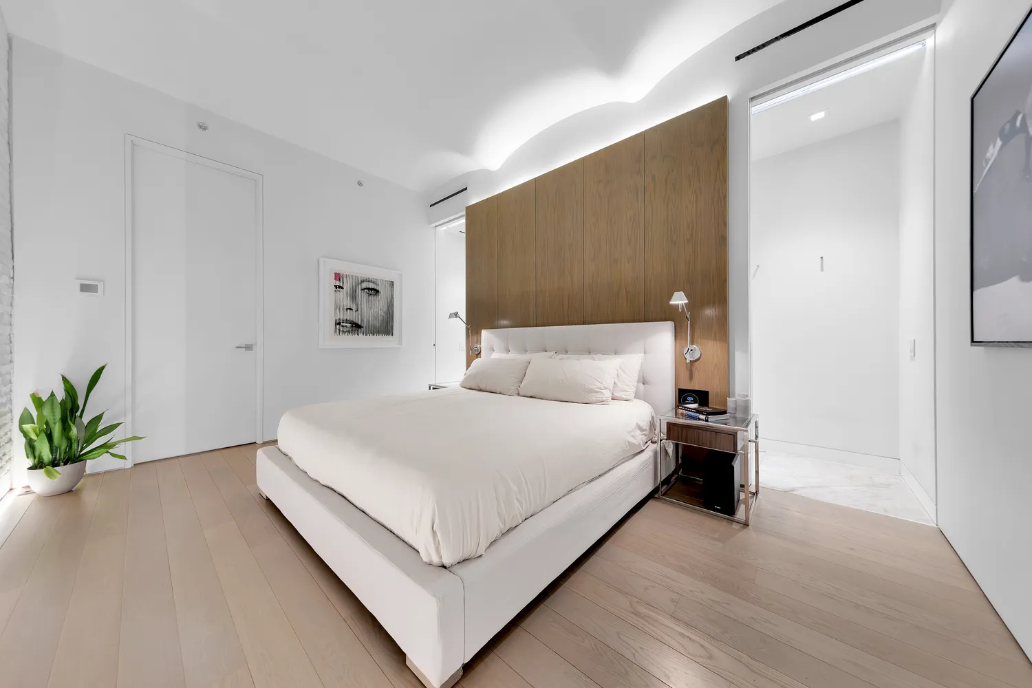 a bedroom with a bed and a potted plant