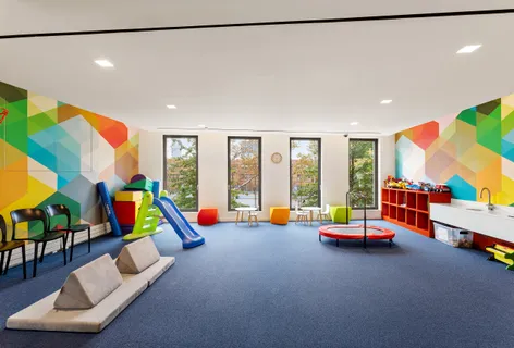 a play room with furniture and a floor to ceiling window