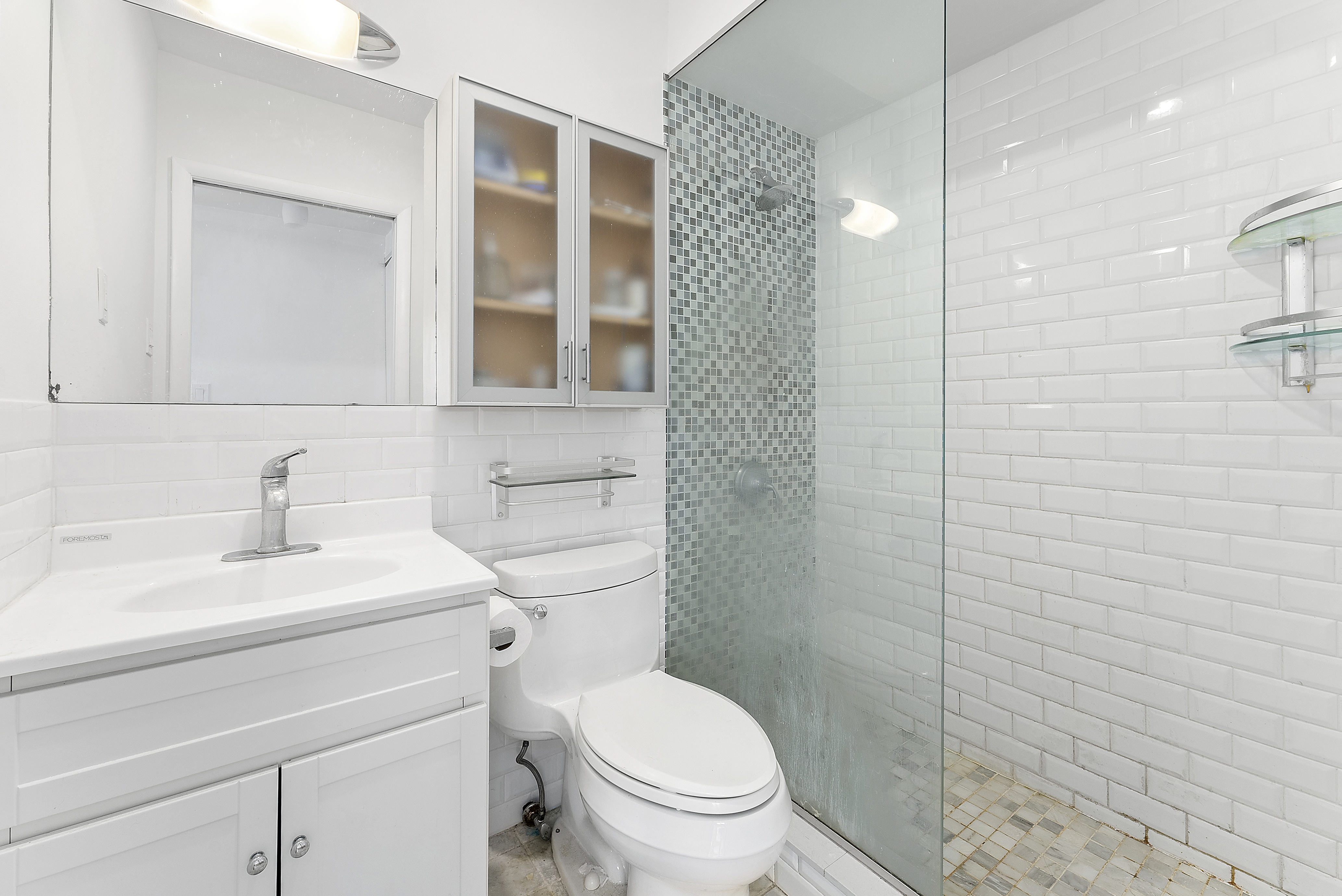 181 7th Avenue, Unit 8D Manhattan, NY 10011 - Photo 3 of 7 a bathroom with a toilet sink vanity and shower