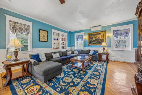 a living room with furniture and painting on the wall
