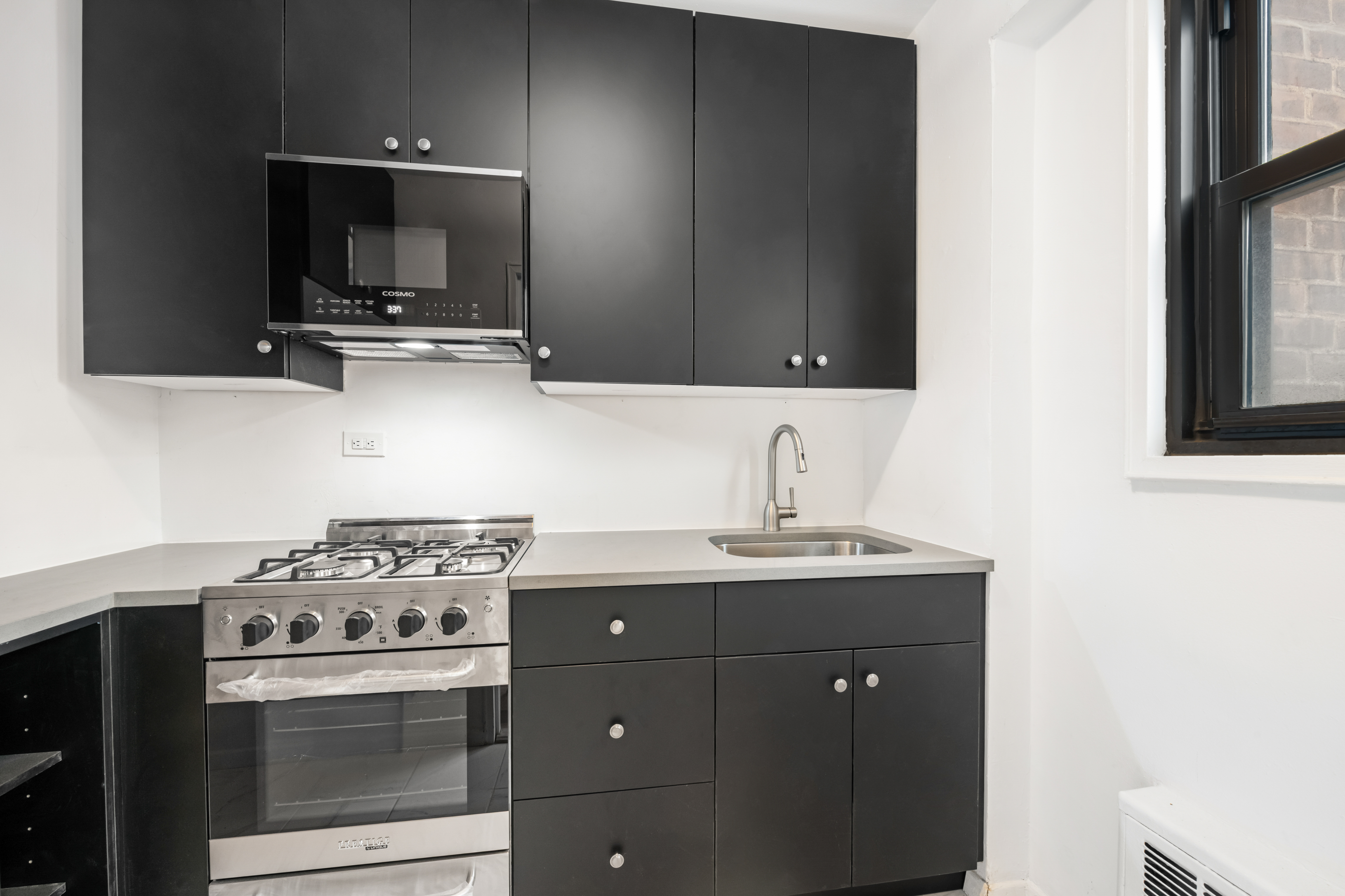 201 West 21st Street, Unit 9A Manhattan, NY 10011 - Photo 8 of 13 a kitchen with a stove and a microwave