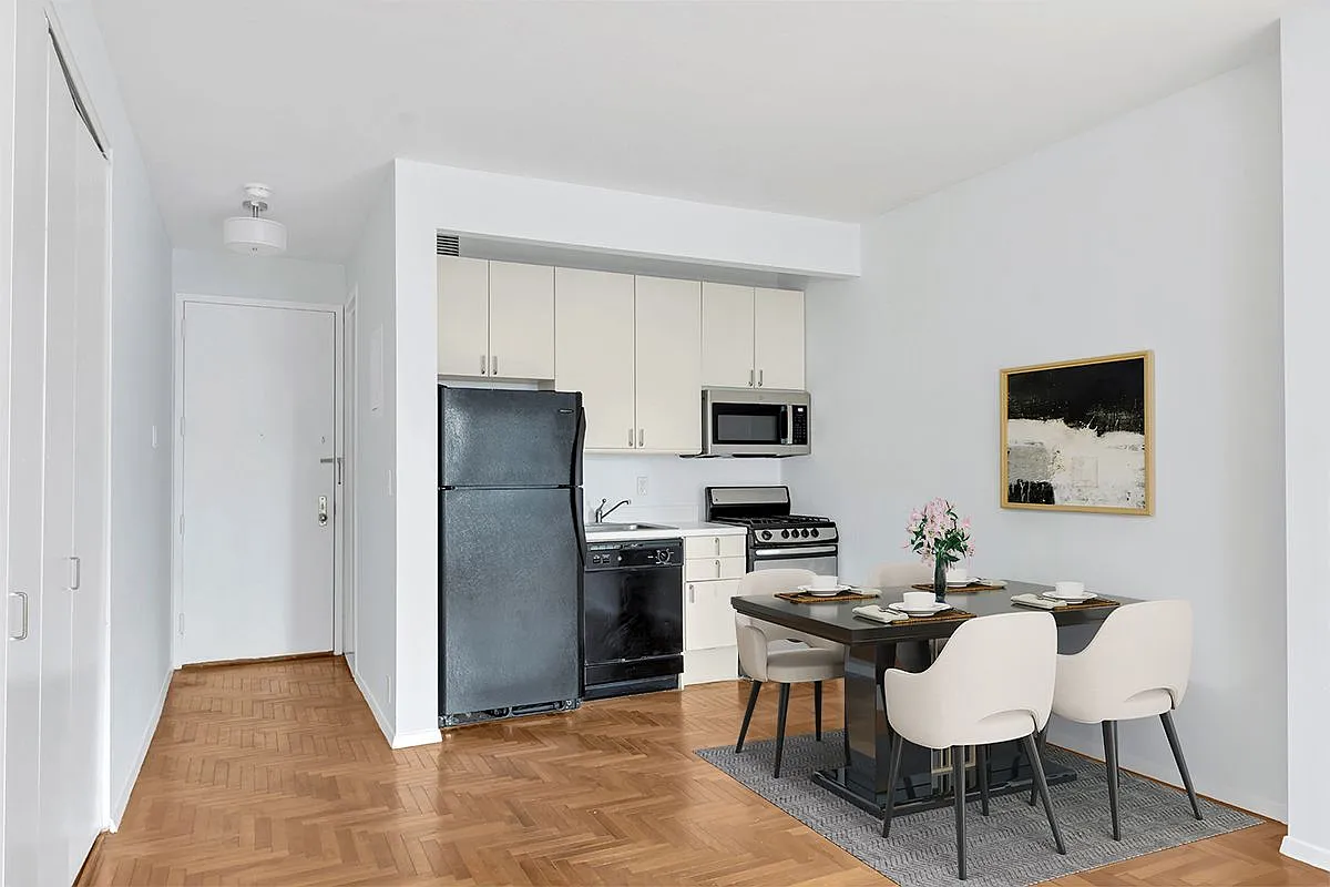301 West 57th Street, Unit 22E Manhattan, NY 10019 - Photo 3 of 13 a kitchen with stainless steel appliances a refrigerator and a stove top oven