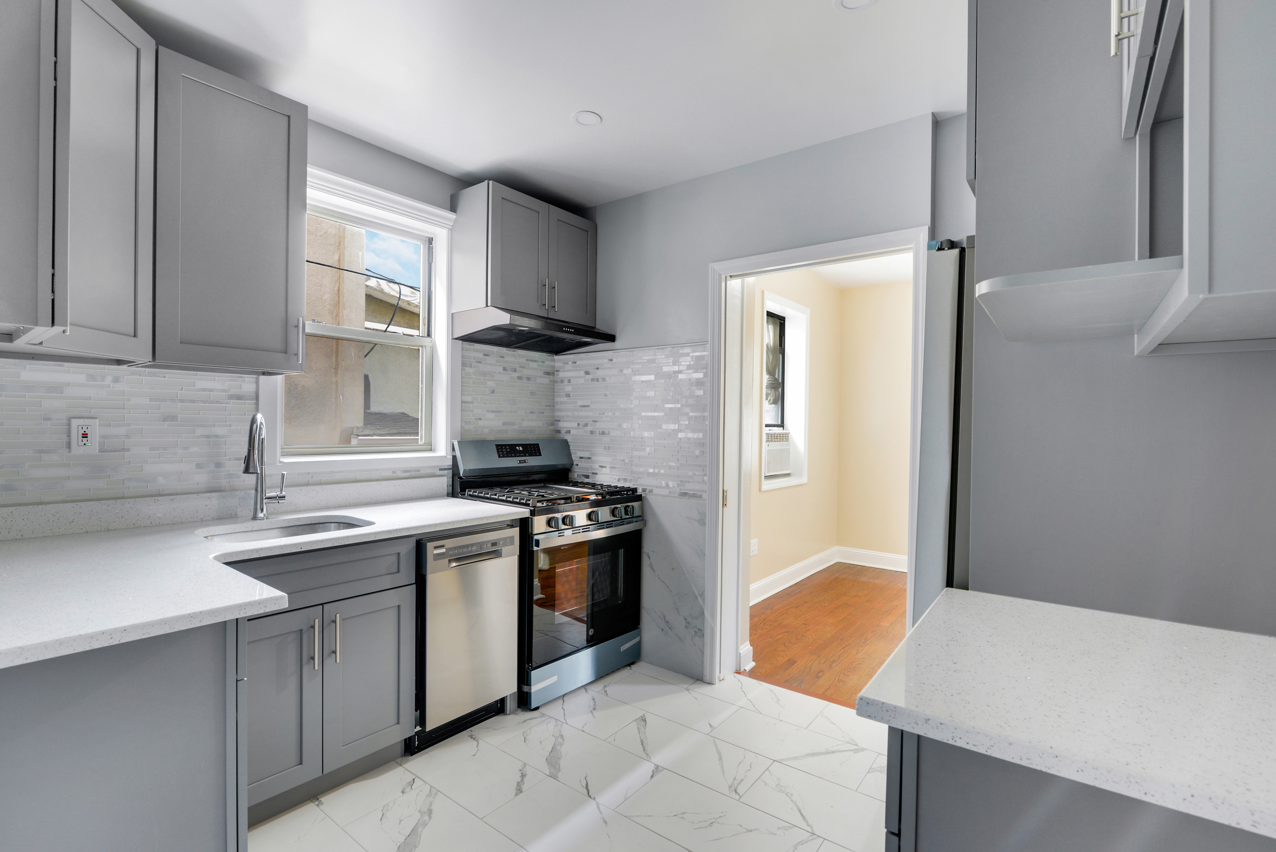 91-11 32nd Avenue, Unit 2 Queens, NY 11369 - Photo 1 of 9 a kitchen with stainless steel appliances granite countertop a sink stove and refrigerator