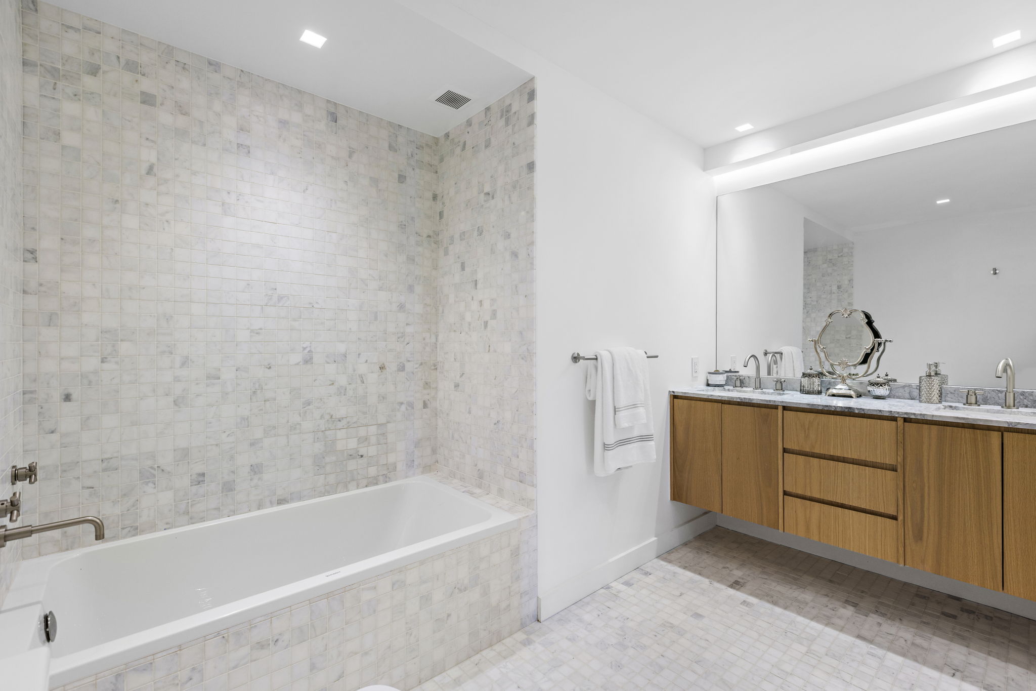 117 East 57th Street, Unit 21H Manhattan, NY 10022 - Photo 12 of 25 a bathroom with a tub sink shower and mirror