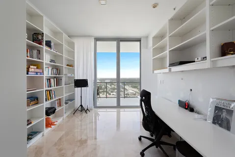 a view of a workspace with furniture and a bookshelf