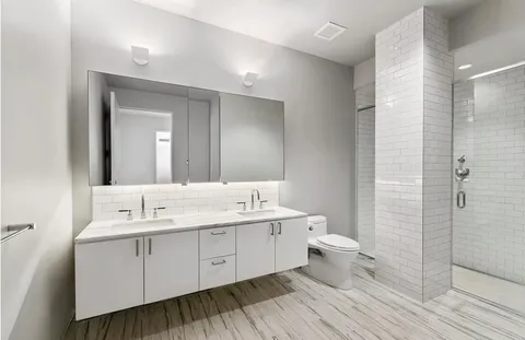 a spacious bathroom with a double vanity sink and a mirror