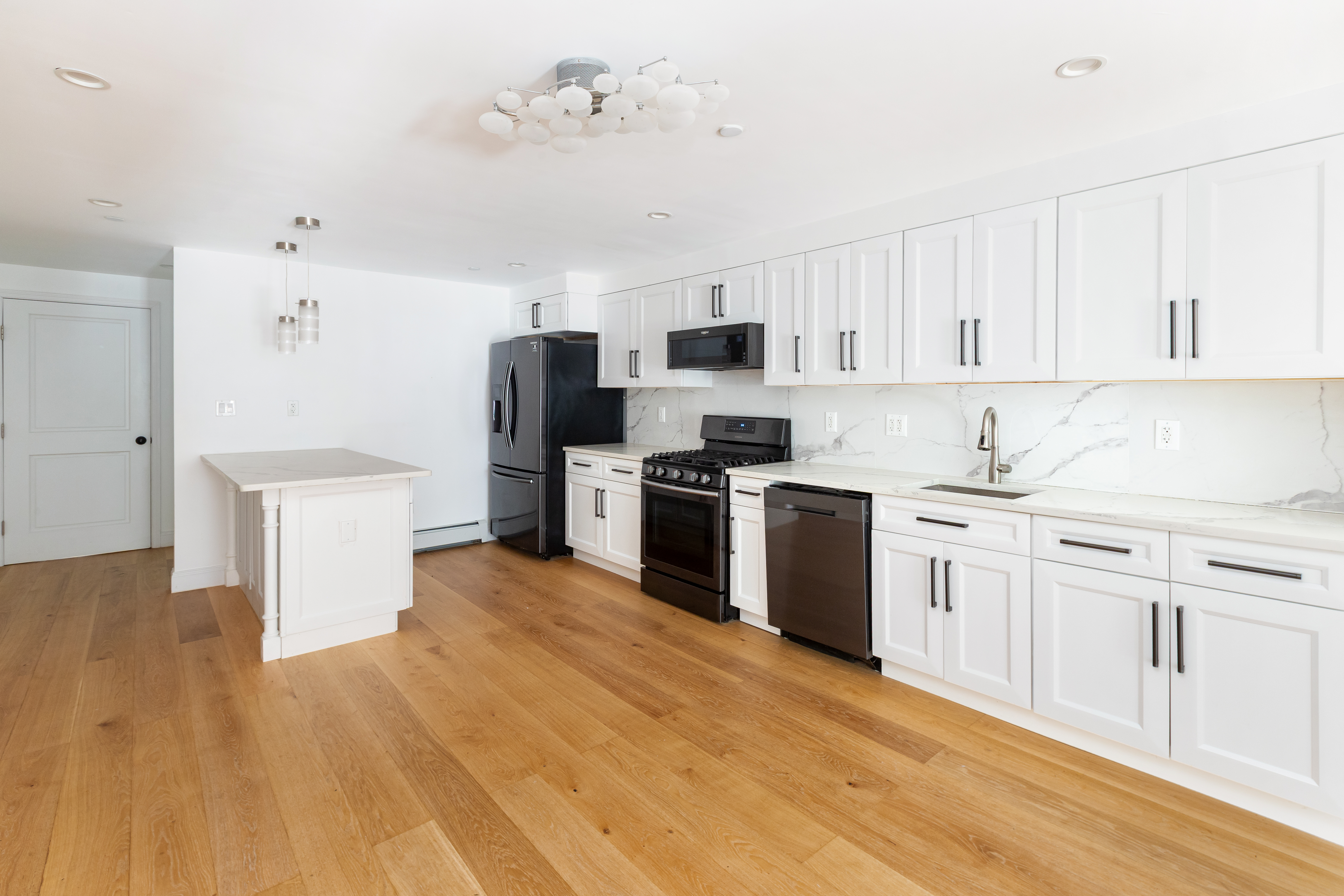 492 Warren Street, Unit GARDEN Brooklyn, NY 11217 - Photo 2 of 8 a kitchen with stainless steel appliances a stove top oven a sink a refrigerator white cabinets and wooden floor