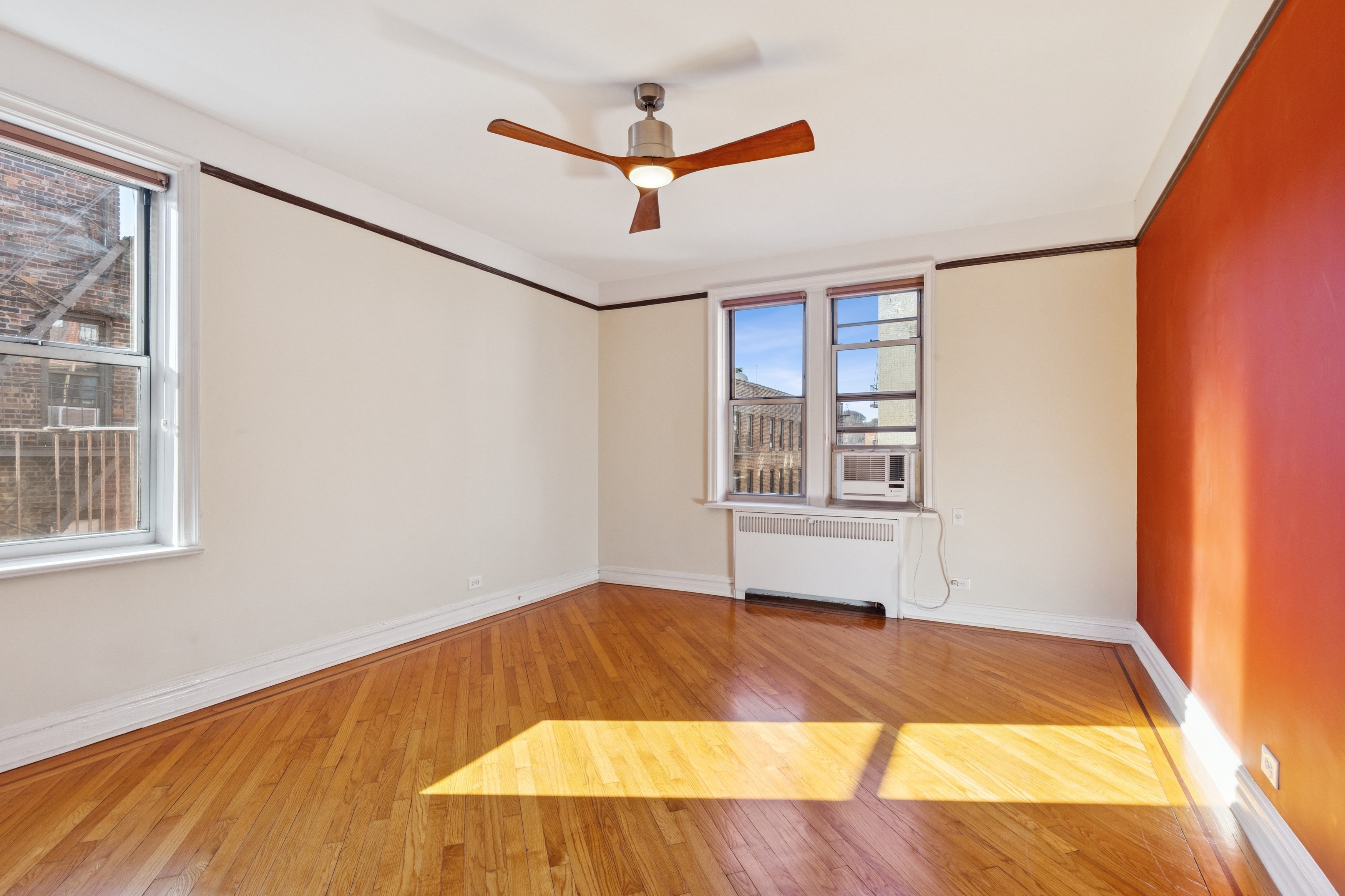680 West 204th Street, Unit 5E Manhattan, NY 10034 - Photo 7 of 23 an empty room with windows and ceiling fan