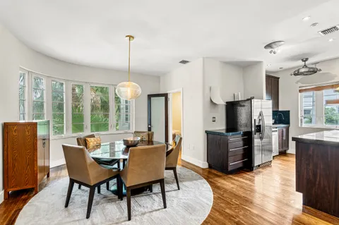 a dining room with furniture a chandelier and wooden floor